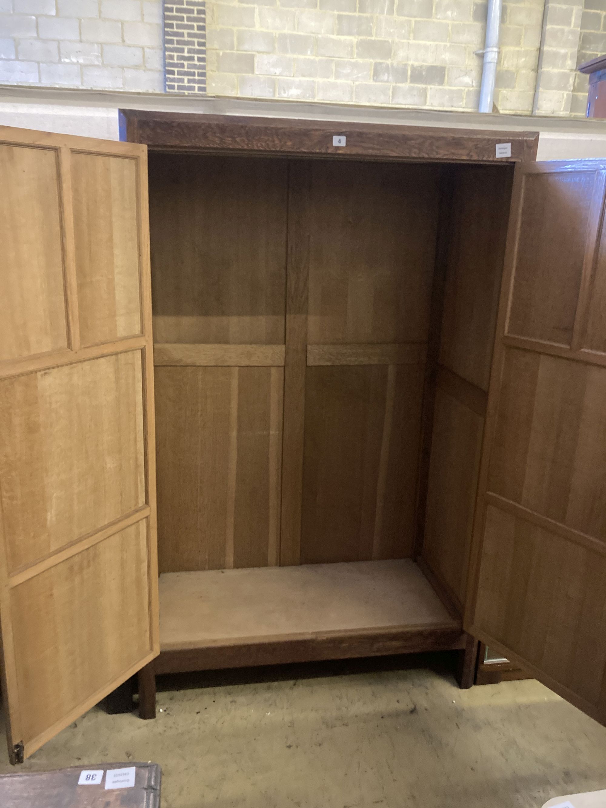 An Arts & Crafts style panelled oak two door wardrobe, width 105cm, depth 55cm, height 168cm